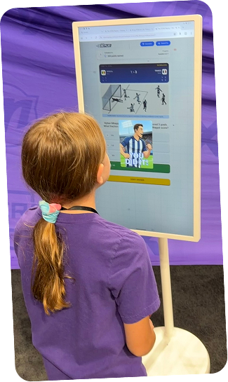 Niña interactuando con una pantalla vertical de deporte